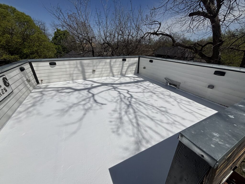White low-slope roof membrane with perimeter walls and rooftop equipment