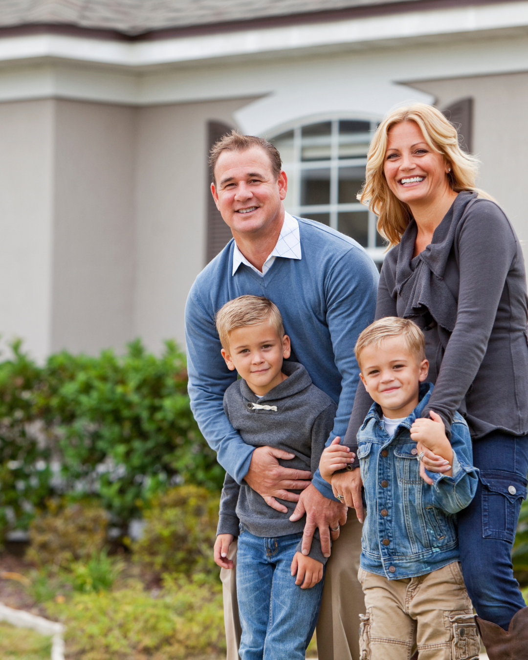 Happy Austin family standing in front of their completed home after a roofing project